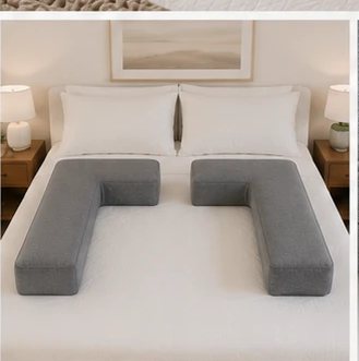 A pair of Cradle pillows styled on a made bed in a warm, restful bedroom